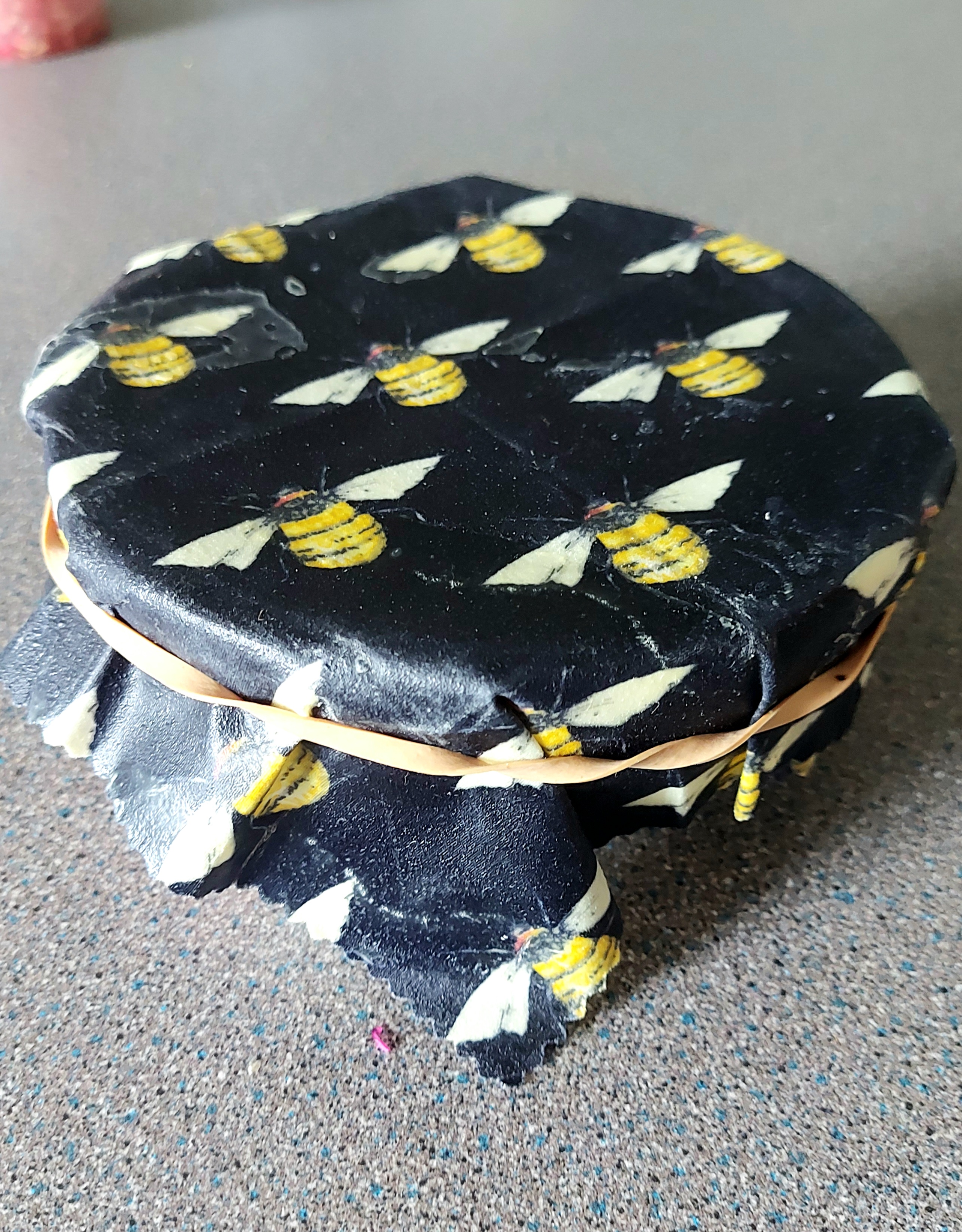 a dark blue beeswax wrap coevring the top of a bowl