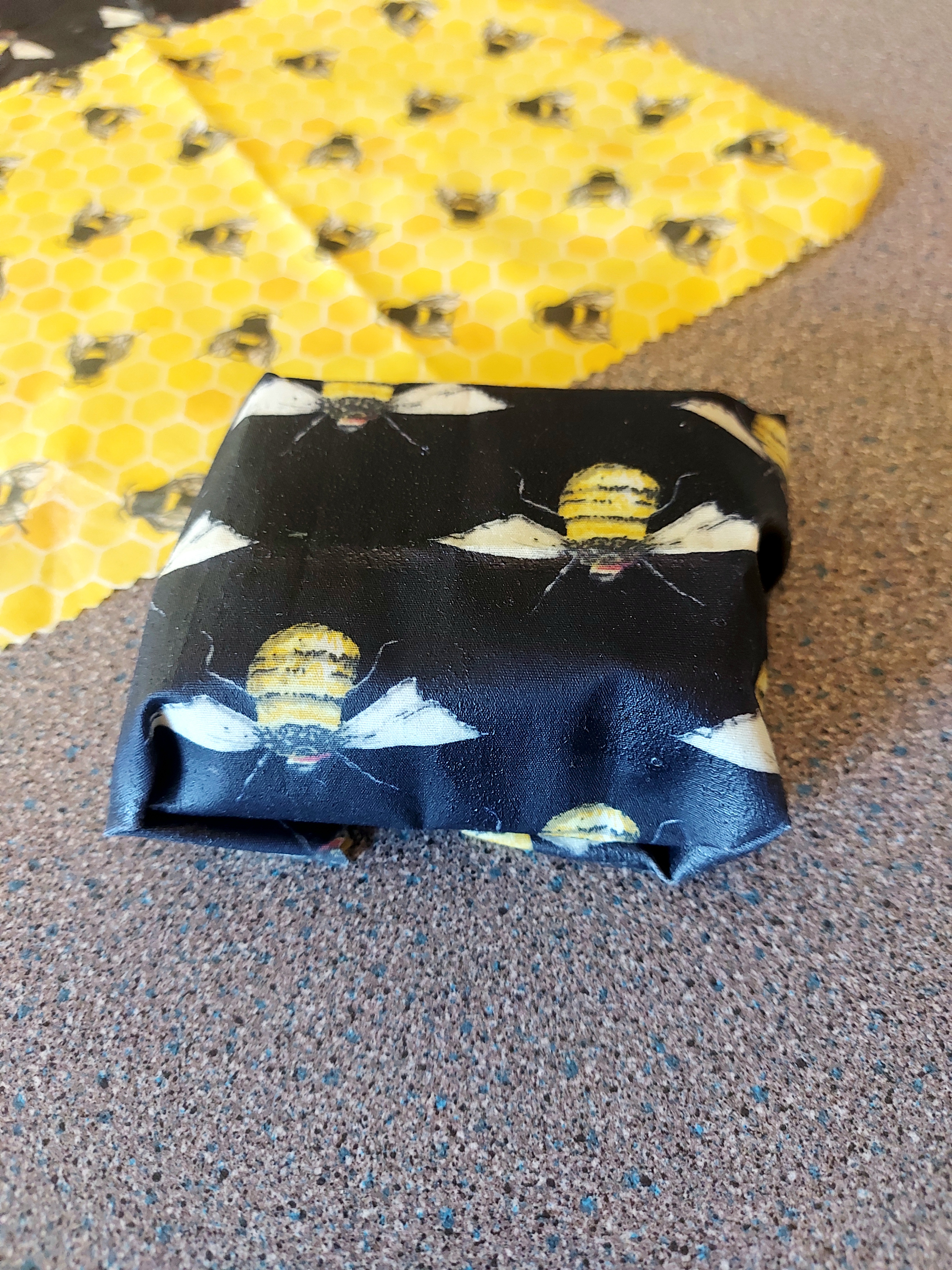 a dark blue beeswax wrap wrapping a rectangular piece of cake